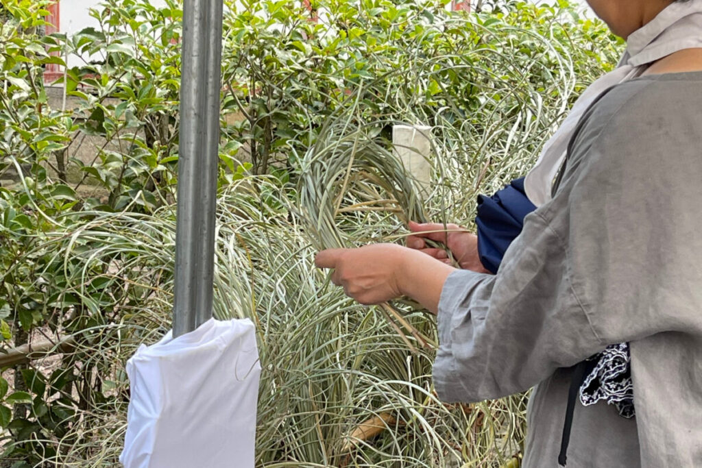 疫神社夏越祭で持ち帰り用の茅を手に取る参拝者