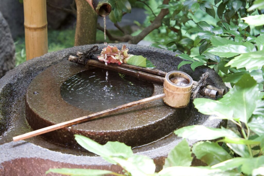 麓寿庵の主庭　石臼を再利用したつくばいと柄杓（井戸水が流れる）