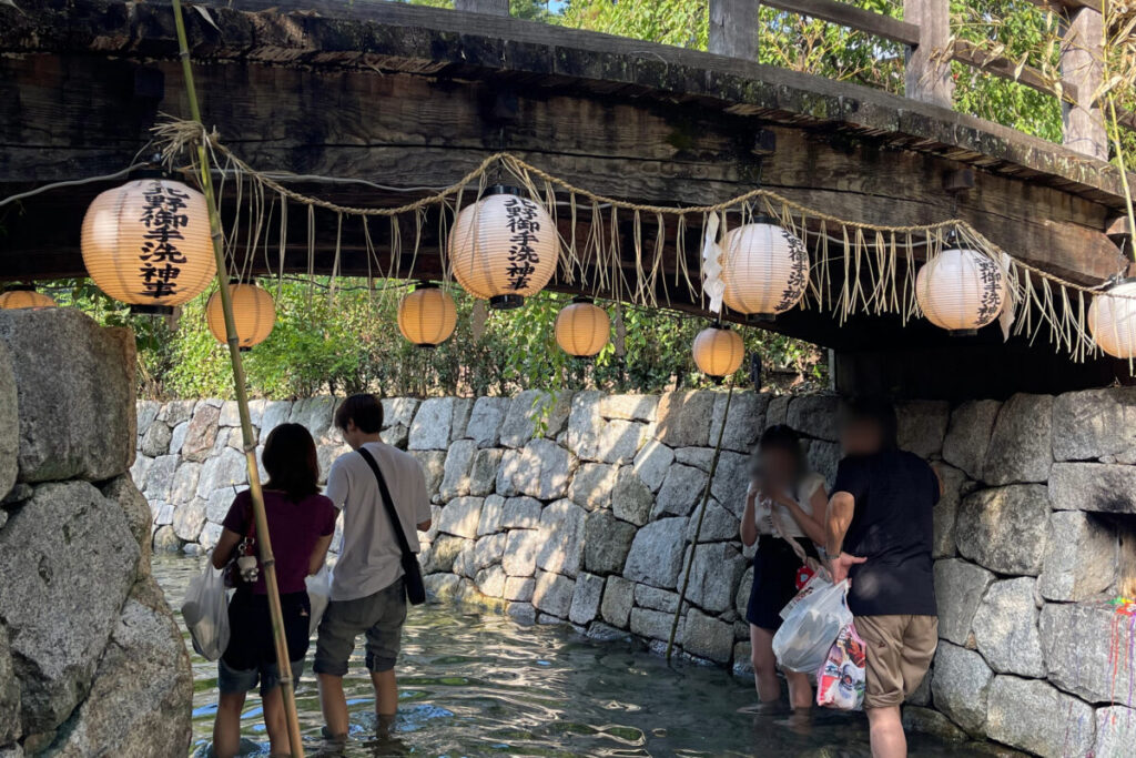 北野天満宮の御手洗祭2026 足つけ燈明神事で御手洗川に足を浸す参拝者