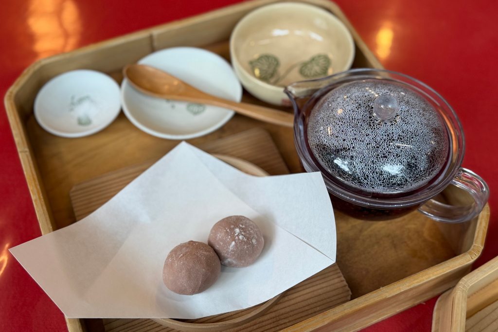 木製の盆に並ぶ申餅と、黒豆が入ったガラスの急須