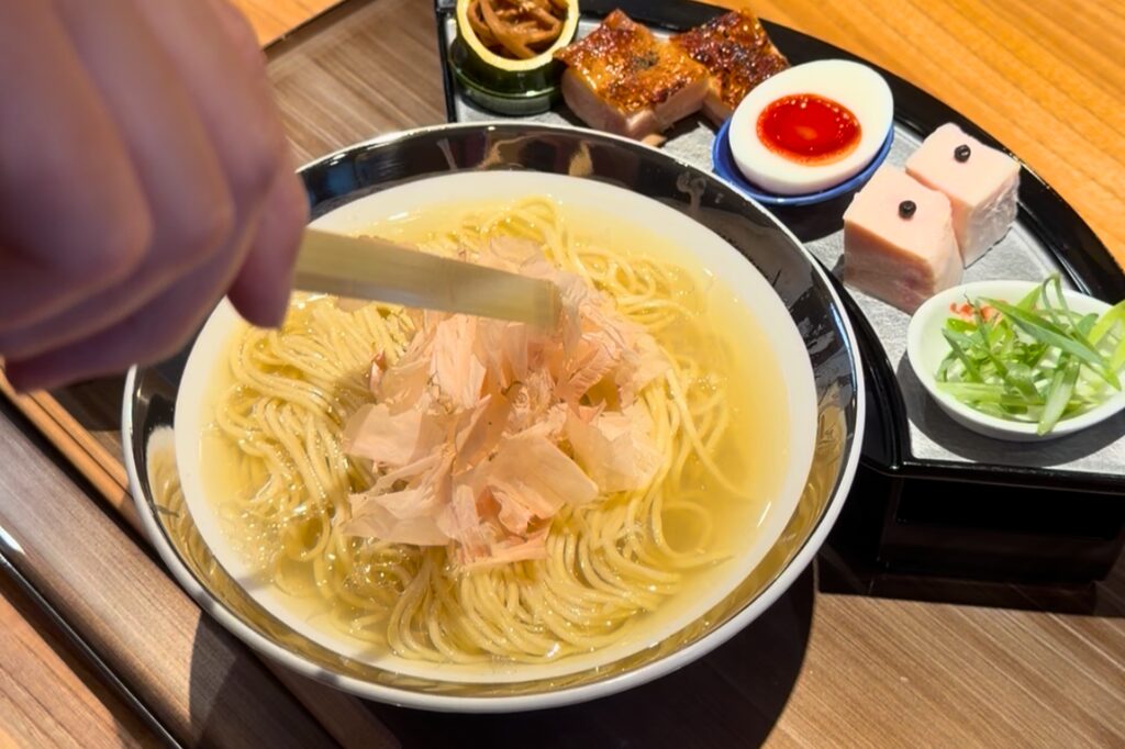 銀の潮そばに削りたての本枯節をのせる様子