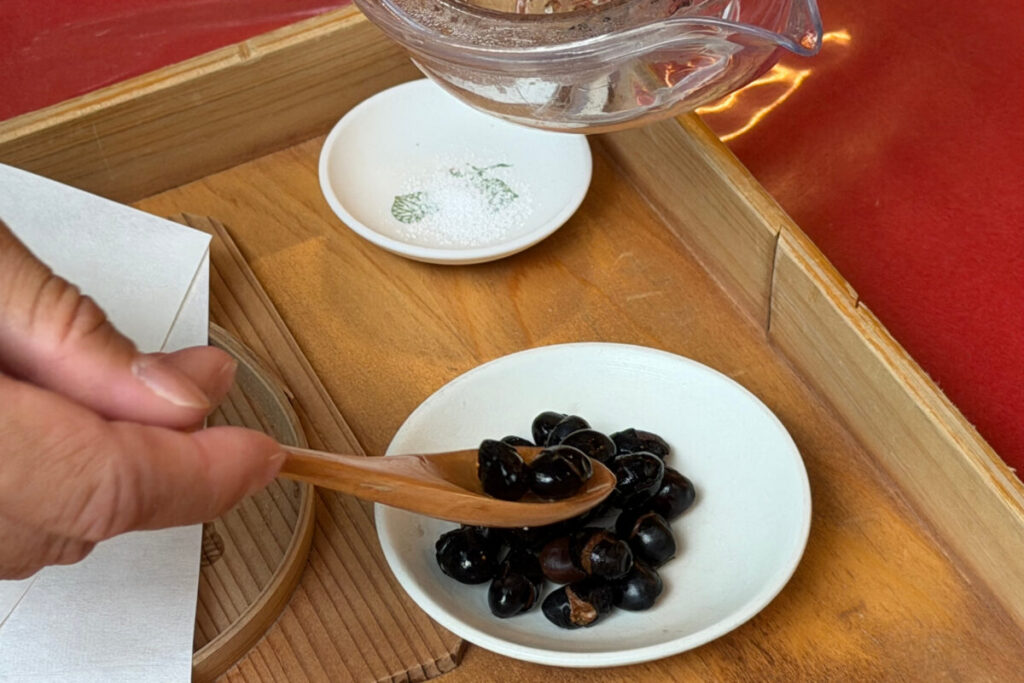 まめ豆茶を飲んだあと、器に残った黒豆を小皿へ移す様子