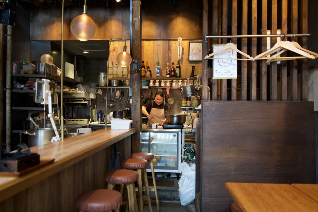 木のカウンターとオープンキッチンがあるキツネ日和の店内
