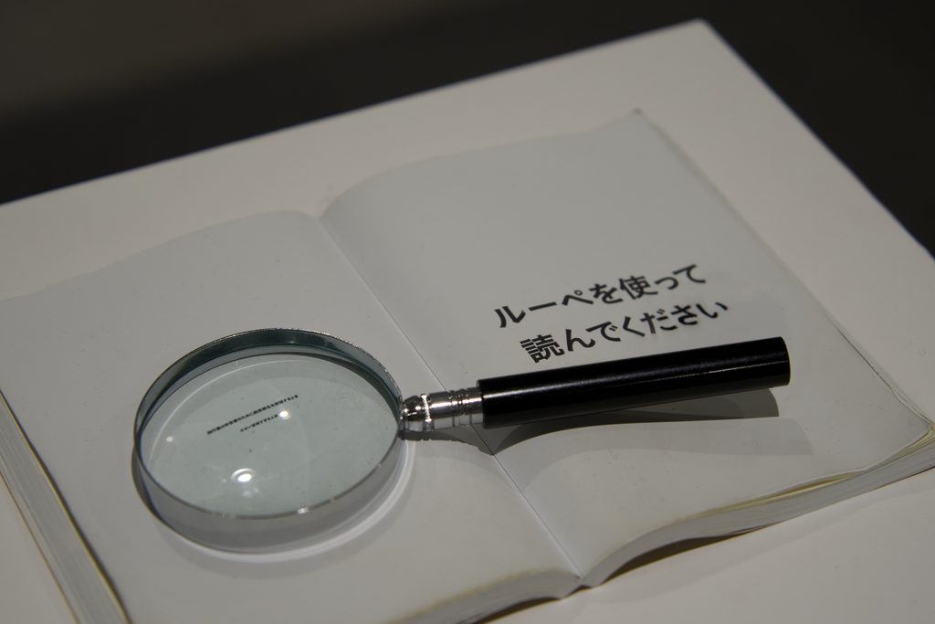 ルーペを使って小さな文字を読む体験型展示