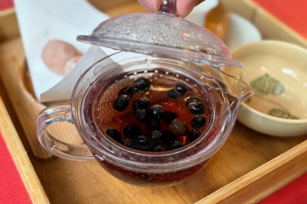 黒豆が入ったガラスの急須でいれるまめ豆茶