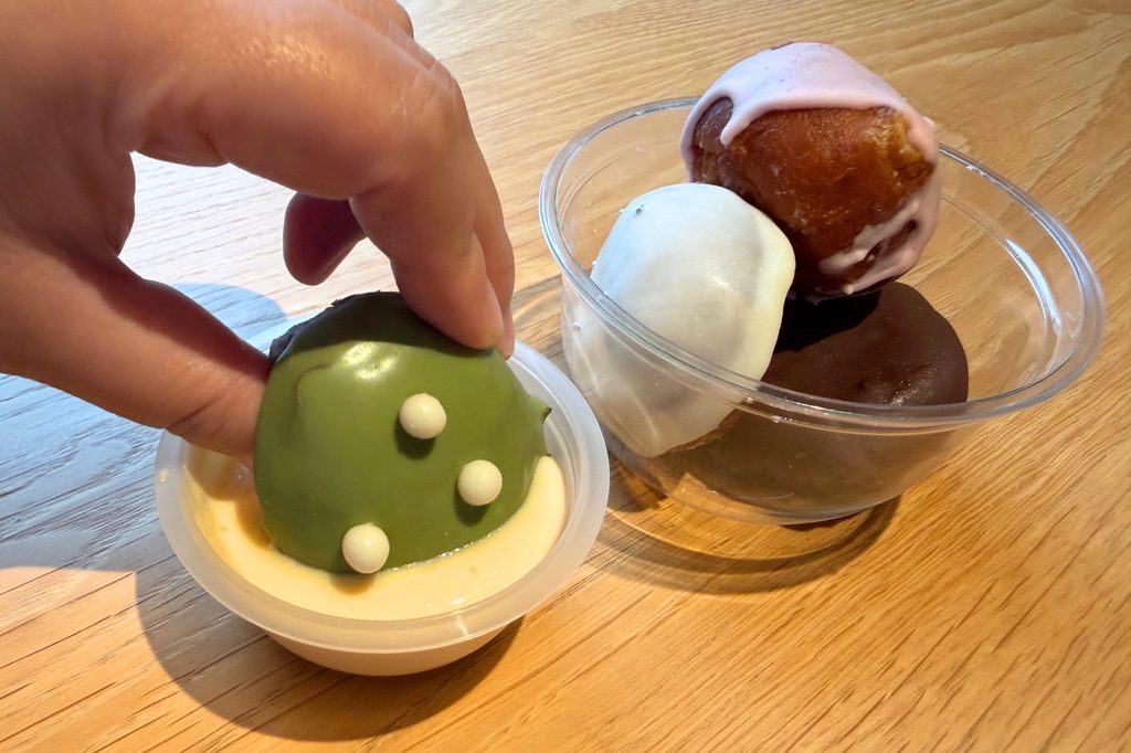 抹茶チョコレートのミニドーナツをハニーチーズディップにつける様子