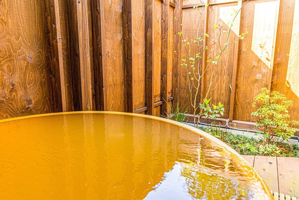 空気に触れて赤茶色に変わる金温泉の露天風呂